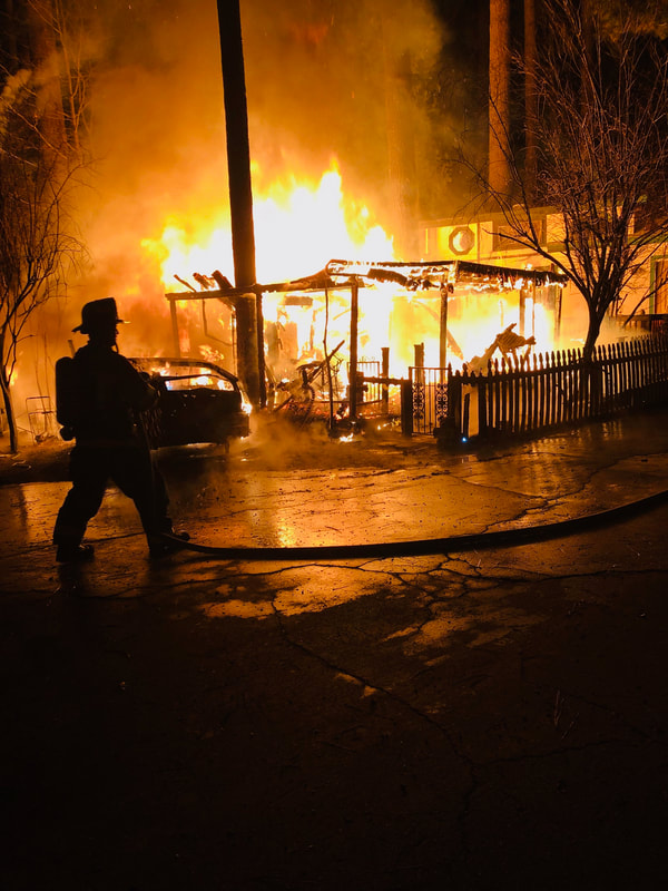 Firefighters battle a house fire in California (illustrative file photo; photo: idyllwildfire.com via Wikimedia Commons, public domain)