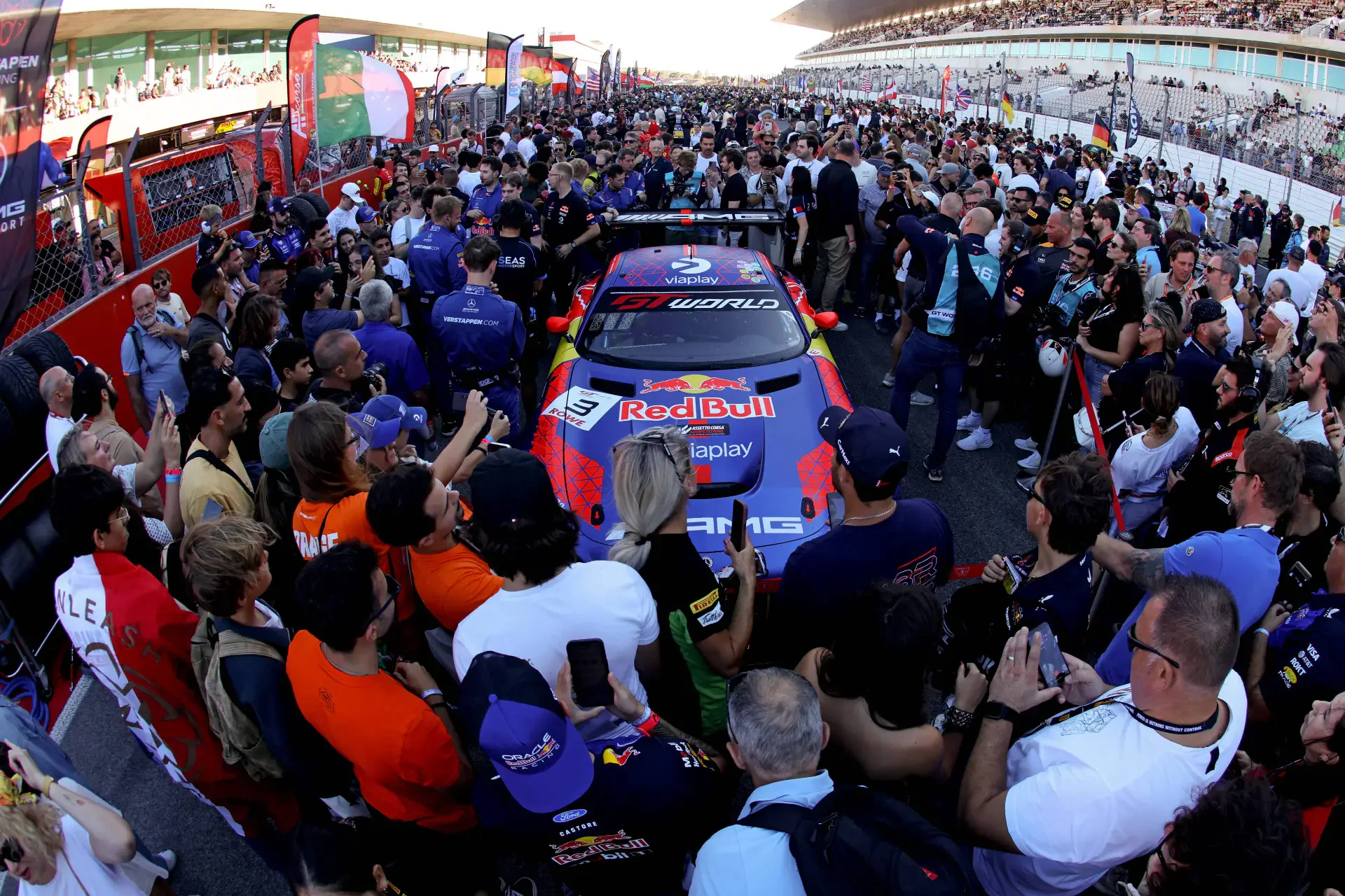 Team Verstappen Racing Mercedes-AMG GT3 car surrounded by a crowd of fans and mechanics on the starting grid.