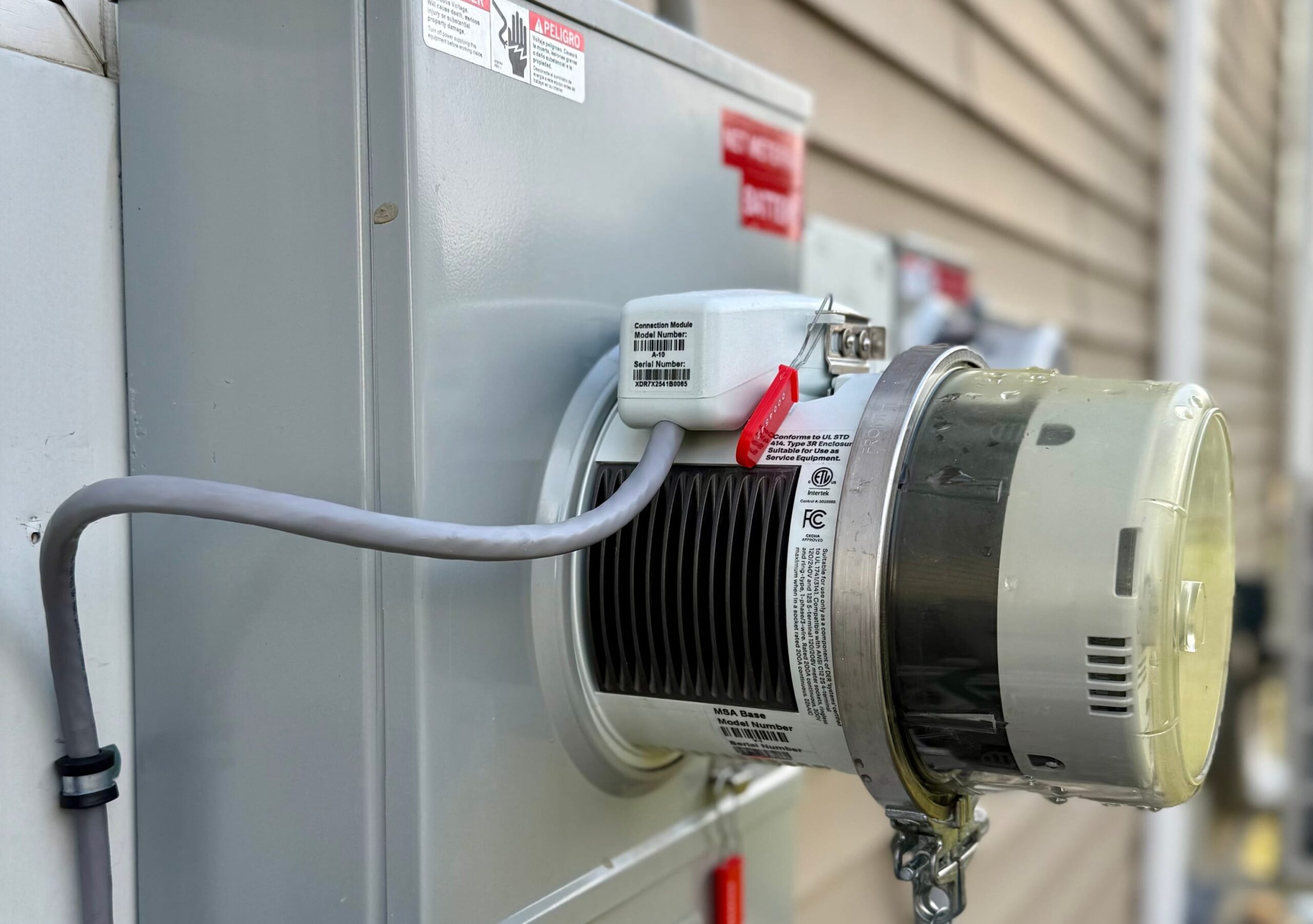 A technician mounts the SolarEdge Nexis IslandDER meter socket adapter into a residential utility meter enclosure on an